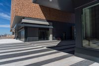 there is an entrance into a modern building on a sunny day with blue skies in the background