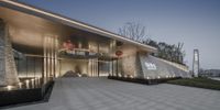 modern building entrance with illuminated fountain at night with concrete clad walls and lights on it