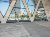 the sidewalk outside a modern building with geometric designs on it's sides and windows