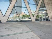 the sidewalk outside a modern building with geometric designs on it's sides and windows