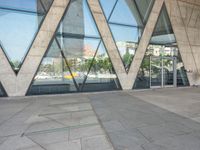 the sidewalk outside a modern building with geometric designs on it's sides and windows