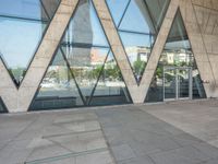 the sidewalk outside a modern building with geometric designs on it's sides and windows