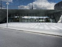 a modern looking building with the reflection of the glass facade on it's side