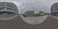 a 360 camera is showing two cars driving by a building with a domed shaped facade