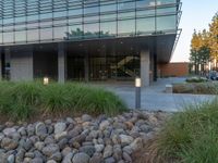 two grey blocks sitting next to a tall building on a sidewalk in front of grass