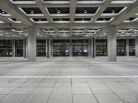 a long empty floor in a modern building with open air duct boxes and lights on the ceiling