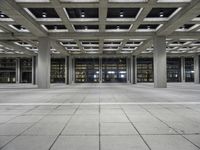 a long empty floor in a modern building with open air duct boxes and lights on the ceiling