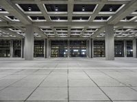 a long empty floor in a modern building with open air duct boxes and lights on the ceiling