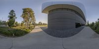 a 360 - fish eye lens shot of a building with a parking lot in front of it