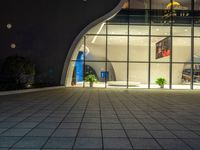 a large modern building in the dark with its windows reflecting the light outside the building