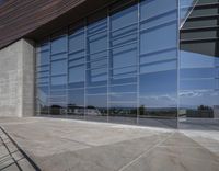 a modern looking building with some big glass windows on the side of the building is blue and has a brown roof