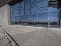 a modern looking building with some big glass windows on the side of the building is blue and has a brown roof