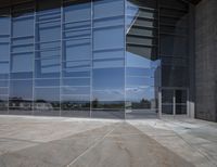 a modern looking building with some big glass windows on the side of the building is blue and has a brown roof