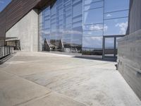 a modern looking building with some big glass windows on the side of the building is blue and has a brown roof