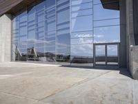 a modern looking building with some big glass windows on the side of the building is blue and has a brown roof