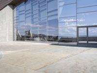 a modern looking building with some big glass windows on the side of the building is blue and has a brown roof