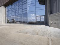 a modern looking building with some big glass windows on the side of the building is blue and has a brown roof