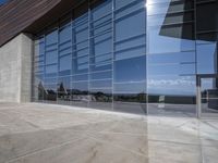 a modern looking building with some big glass windows on the side of the building is blue and has a brown roof