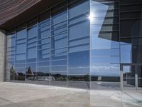 a modern looking building with some big glass windows on the side of the building is blue and has a brown roof