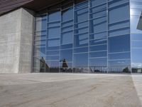 a modern looking building with some big glass windows on the side of the building is blue and has a brown roof