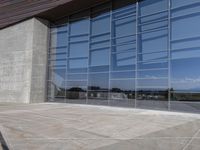 a modern looking building with some big glass windows on the side of the building is blue and has a brown roof