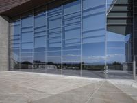 a modern looking building with some big glass windows on the side of the building is blue and has a brown roof