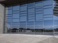 a modern looking building with some big glass windows on the side of the building is blue and has a brown roof