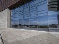 a modern looking building with some big glass windows on the side of the building is blue and has a brown roof