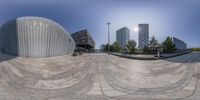 an artistic view of a modern building near a skate park in a city area,