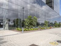 a very modern looking building with green plants in front of it and trees around it