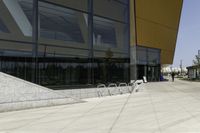 a skateboarder is doing tricks on a ramp outside of a building with glass doors