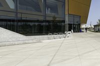 a skateboarder is doing tricks on a ramp outside of a building with glass doors