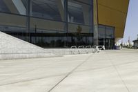 a skateboarder is doing tricks on a ramp outside of a building with glass doors