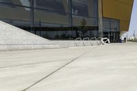 a skateboarder is doing tricks on a ramp outside of a building with glass doors