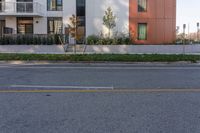 the back corner of a modern building with grass in front of it and trees in the foreground