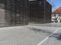 a man on a skateboard is leaning against a building while a bicycle leans against the wooden side wall