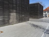 a man on a skateboard is leaning against a building while a bicycle leans against the wooden side wall