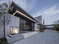 a glass door to a modern building that has a lit up window in it's front