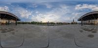 two 360 - spherical pictures of buildings and people walking in front of them under a cloudy sky