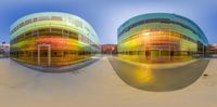 two modern buildings that look like spheres with reflections of each other and one red apple and the other orange, yellow