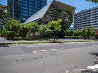 modern looking buildings near street next to sidewalk and trees on pavement and street side in city