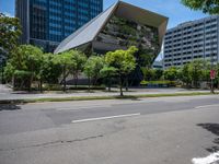 modern looking buildings near street next to sidewalk and trees on pavement and street side in city