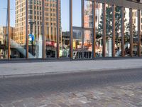 a woman standing next to the road on her cell phone outside of an office building