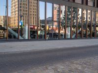 a woman standing next to the road on her cell phone outside of an office building