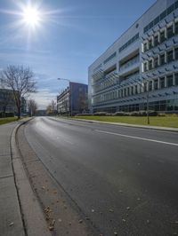 a street is empty in front of an office building with many windows on the second floor