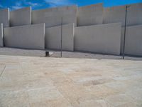 the gray concrete walls of a building have a line of steps on the left side