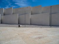 the gray concrete walls of a building have a line of steps on the left side