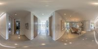 a modern kitchen and dining area, in a spherical panoramic view of the entrance to the home