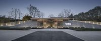 entrance of the home of an architecturally designed man, that is lighted up in warm light