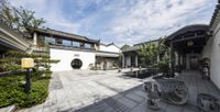 the courtyard in a white and black chinese style house with an outdoor patio area that includes seating areas, fire pits